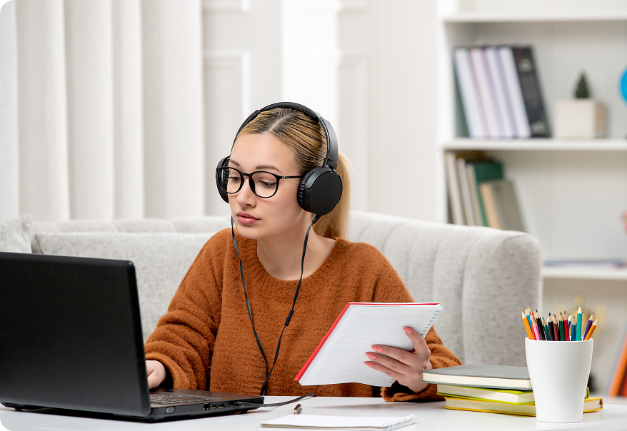Дівчина в наушниках із ноутбуком і блокнотом